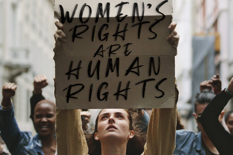 Photo of Woman holding poster that states "Women's Rights are Human Rights"