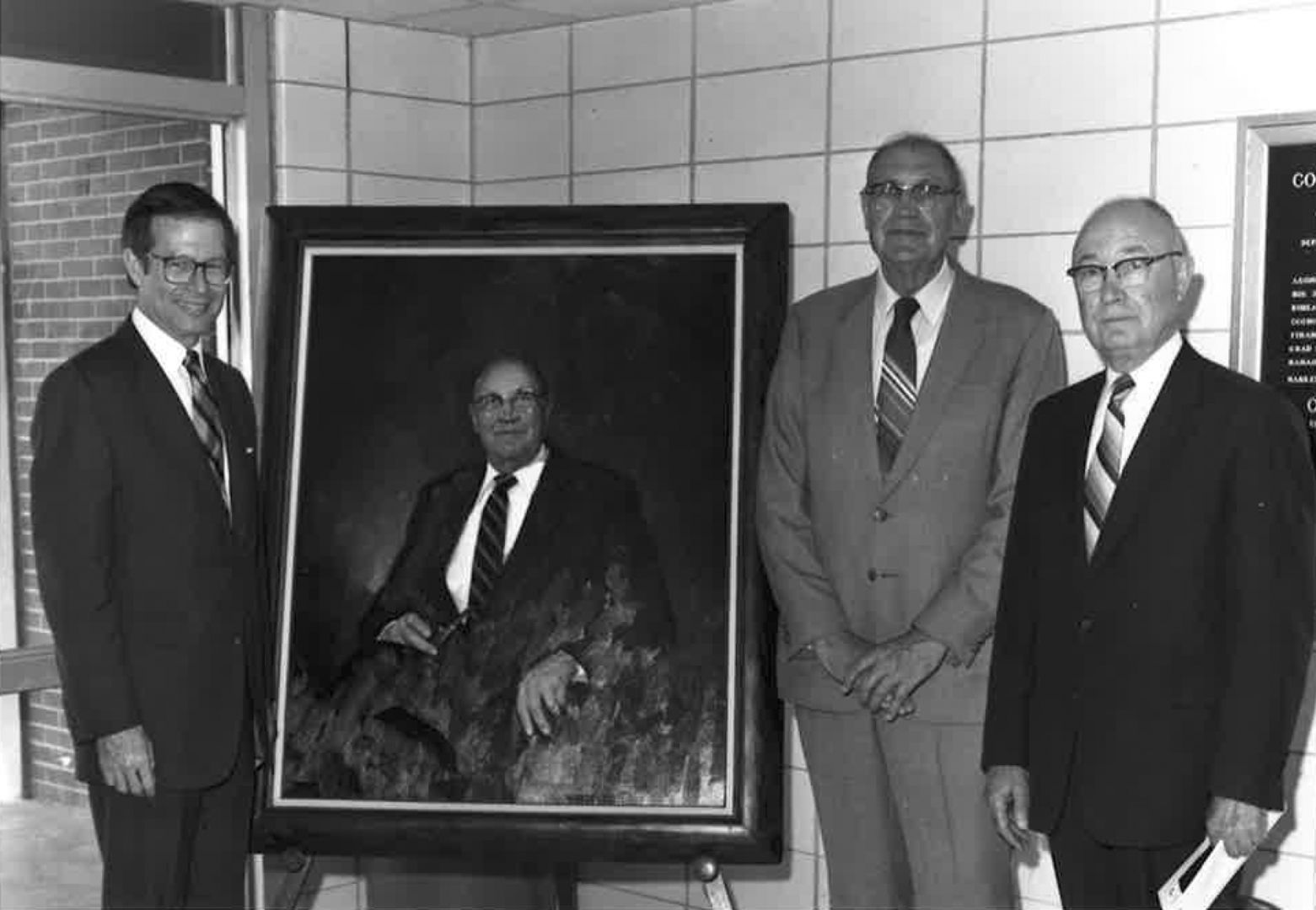 Men pictured with portrait of Dr. Joseph Greene