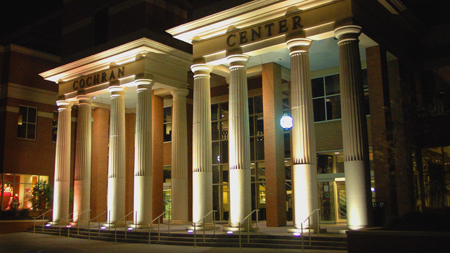 Exterior photo of front of Thad Cochran Center at night.