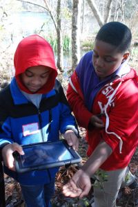 Students using iPad on nature hike