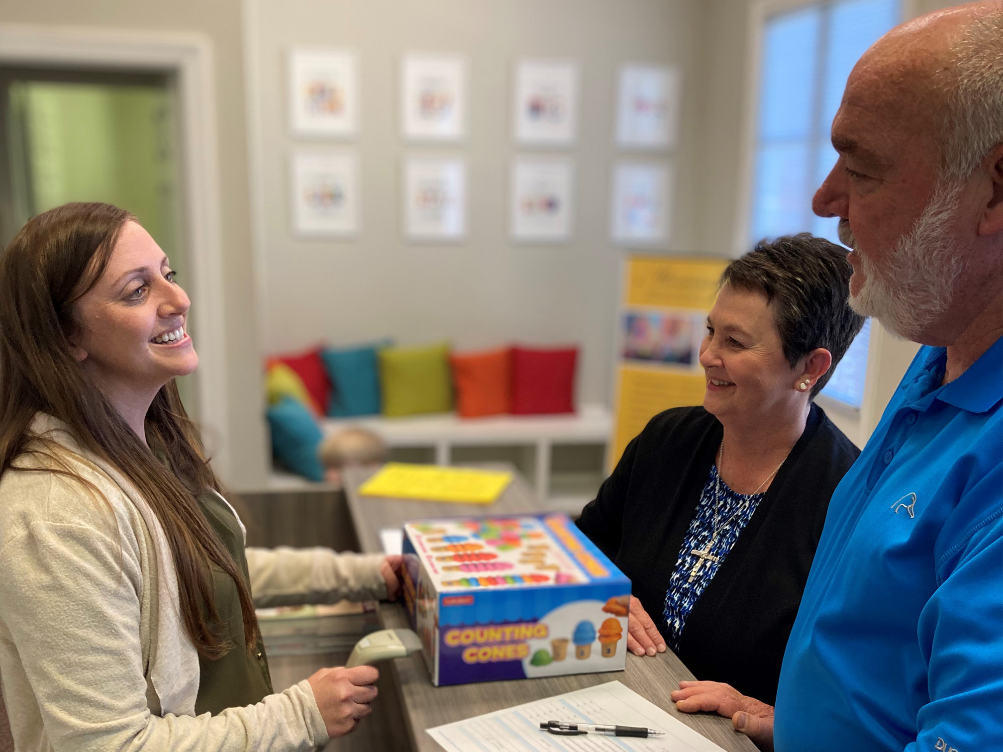 MECIC Staff Member Helping Grandparents Check Out Materials