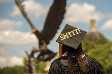 Student with SMTTT Written on Graduation Cap, in Front of Lofty