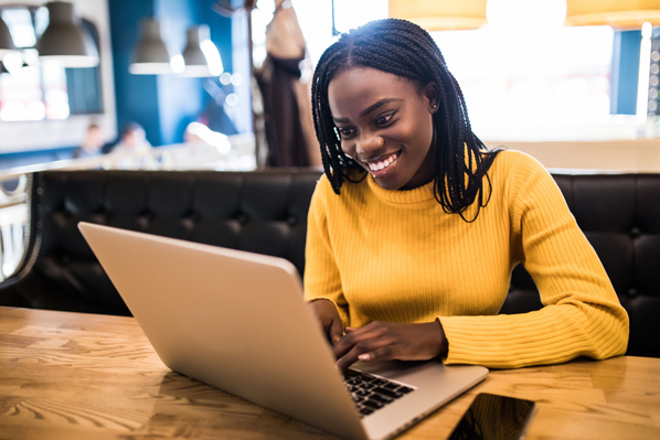 Young african woman typing on laptop