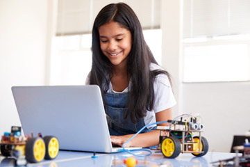 photo of female student with computer and robotics