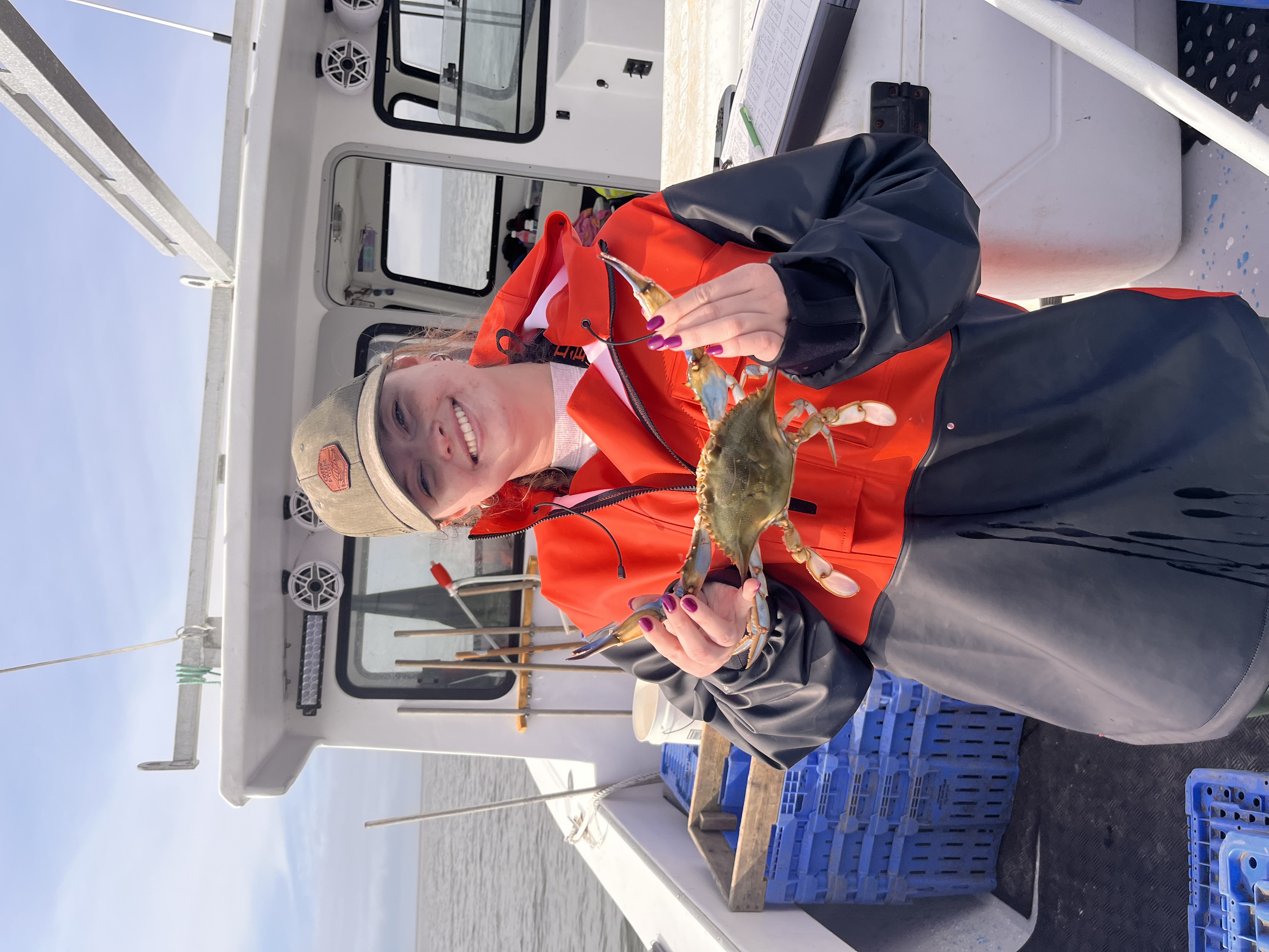 Micayla Cochran holding a blue crab on boat