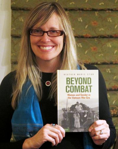 History professor Dr. Heather Stur with a copy of her new book &quot;Beyond Combat: 