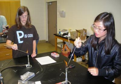 Jamie Morrison, left, a science education teacher with the Oak Grove School District, and Lily Li, a doctoral student in science education at Southern Miss, participate in a glass-making exercise during the ASM Materials Camp 