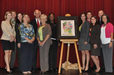 Mississippi Gaming Commission Chairman Jerry St. Pé, fifth from left, is presented original artwork from University of Southern Mississippi students, graduates and faculty of the Casino, Hospitality and Tourism degree program. 