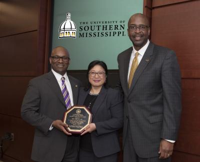 From left are: Trustee Shane Hooper, University of Southern Mississippi (USM) honoree Dr. Chin-Nu Lin, USM President Rodney D. Bennett