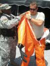 Major Green helps Sgt. 1st Class Christopher Watts with his haz-mat suit.