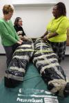 Nursing faculty prepare to unwrap SimMan following the move.