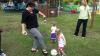 Coach Joye Lee-McNelis plays kick ball with one of the children.