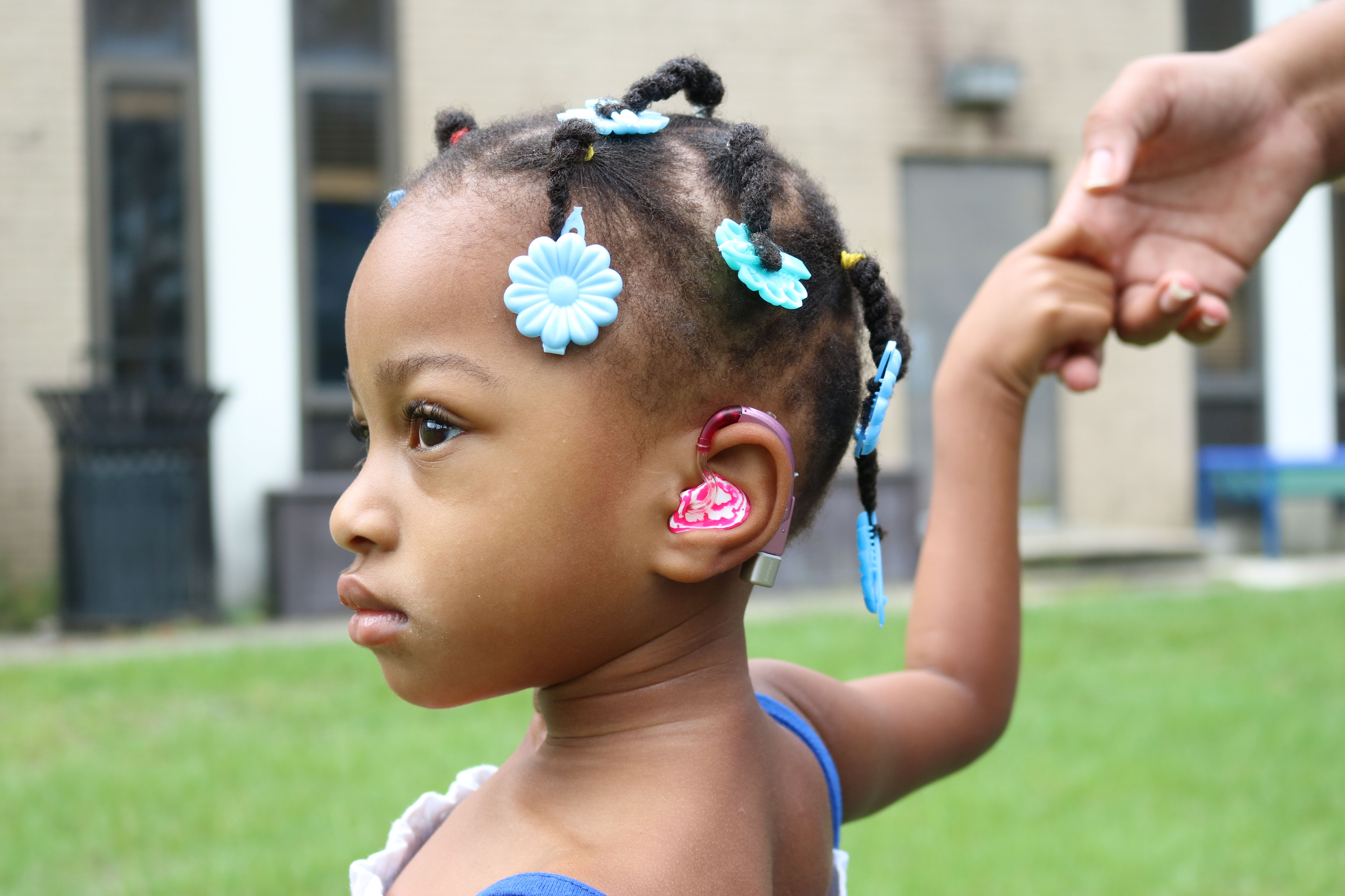 child wearing new hearing aid device