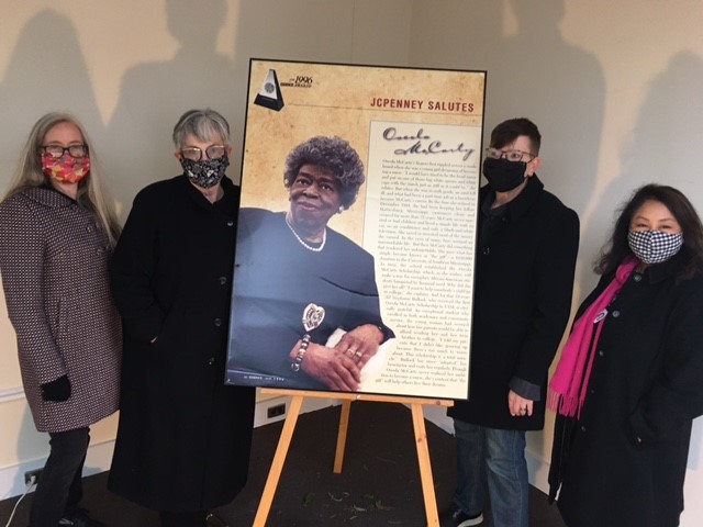 Staff member with Oseola McCarty poster