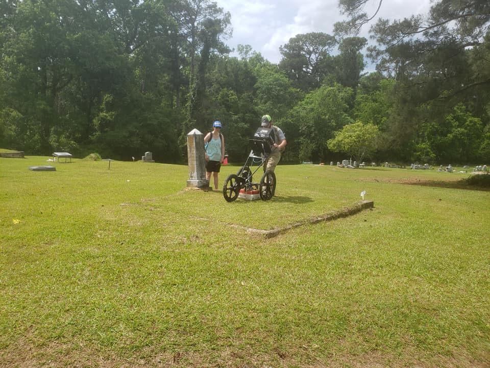 Two people with research equipment in the cemetery