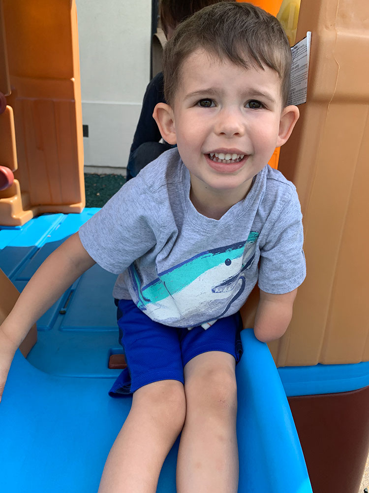 A little boy plays on a slide