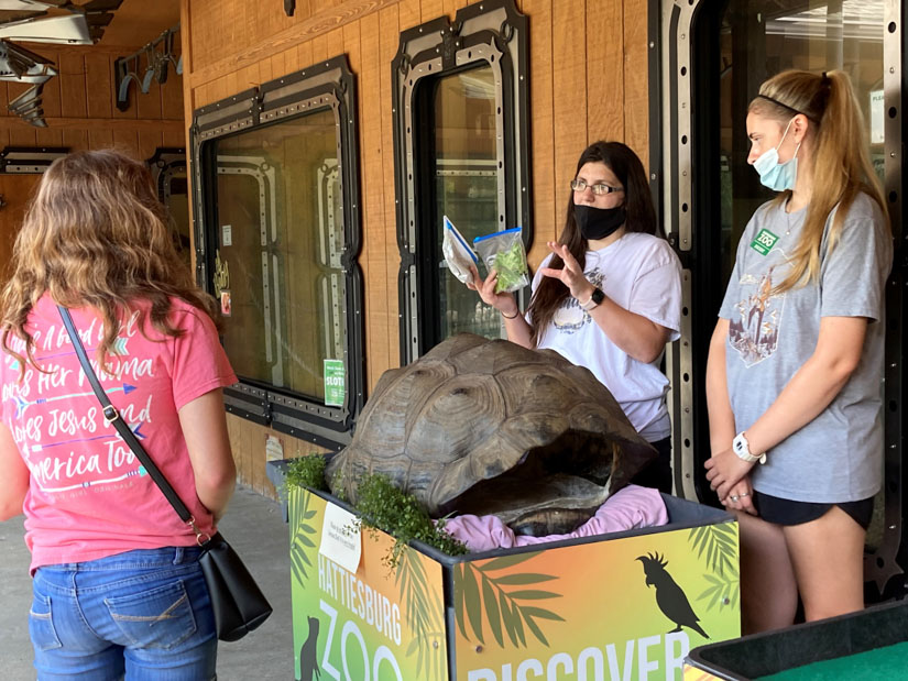 Candy Clark and Emma Atwood share information with zoo guests about the diet of the Galapagos Tortoise.