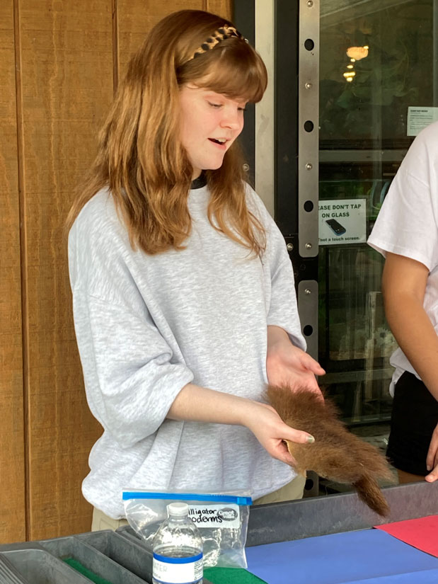 Caroline Ramsey provides information about the coat of the black bear to zoo visitors.