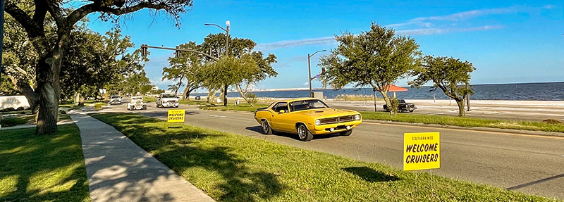 gold sporty classic car cruising the highway on the beach