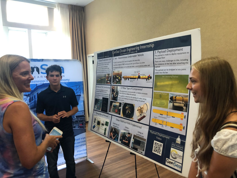 Marine biologist Dr. Kim de Mutsert, left, questions Walker Lyons of Vancleave High School and Sallie Ann Schmidt of Ocean Springs High School about their experiences working on an autonomous underwater vehicle during their ocean engineering internship. (Photo by Tara Skelton). 