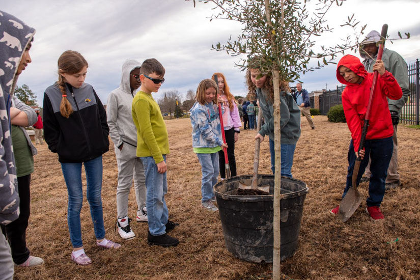 Students from the DuBard School for Language Disorders at The University of Southern Mississippi help plant trees as part of Arbor Day festivities. (Photo by Kelly Dunn)