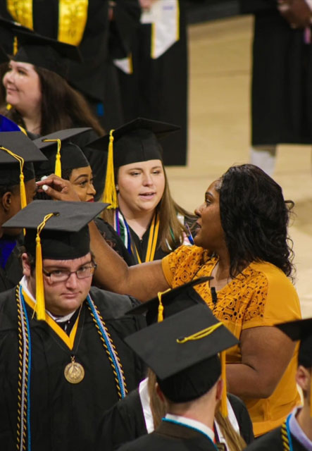 USM Assistant Registrar Dana Berry assists graduates with seating instructions during commencement exercises at the university (submitted photo).