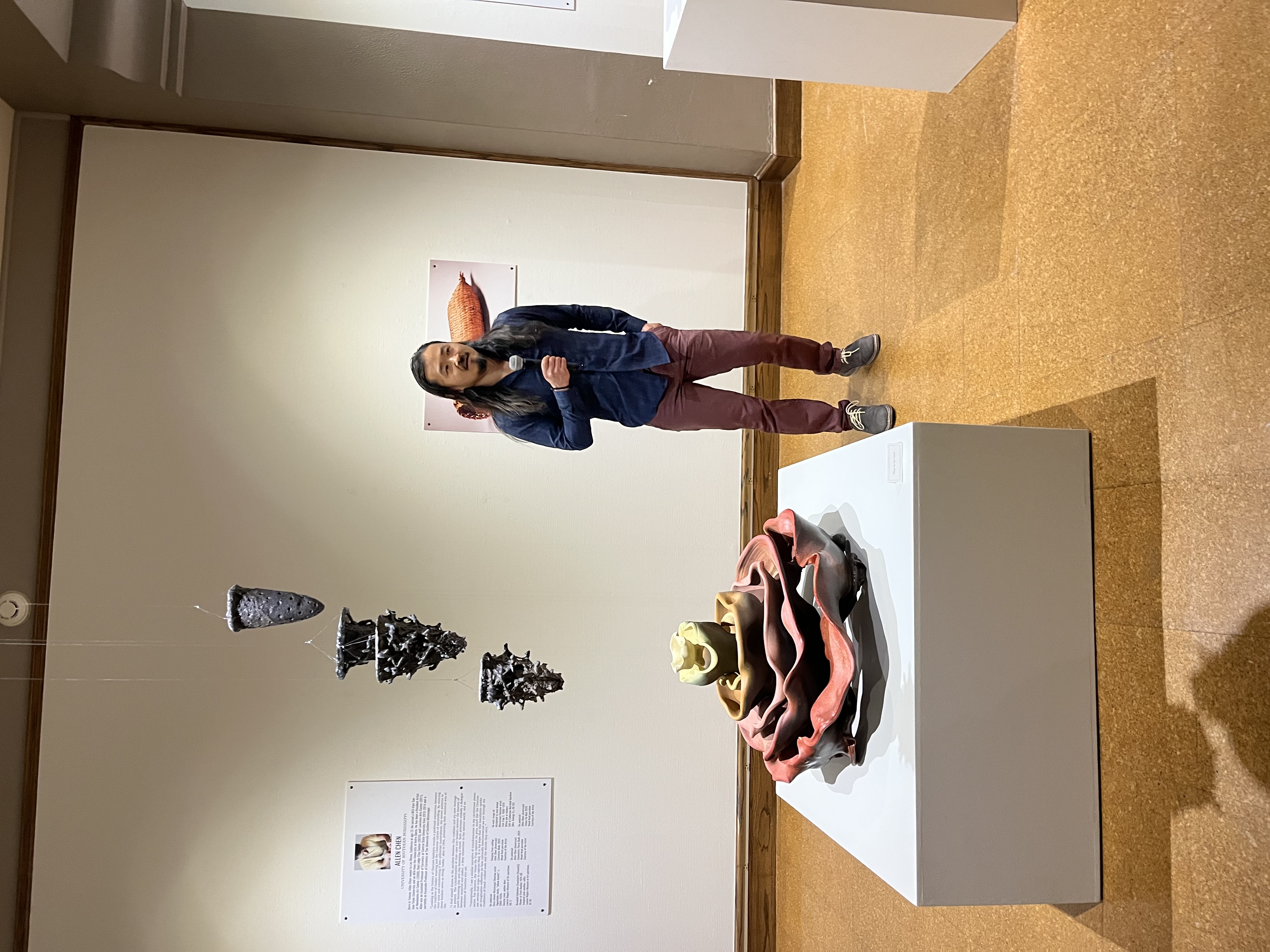 Man standing next to a floral ceramic installation
