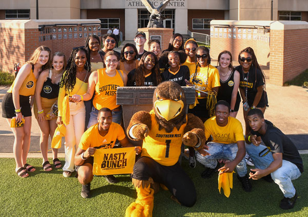 Students dressed in black and gold school colors with mascot Seymour