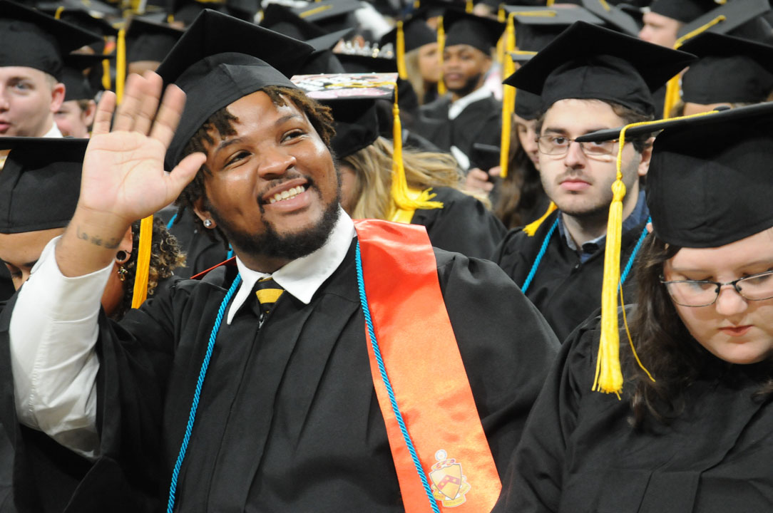 USM student waves to family and friends at commencement. 