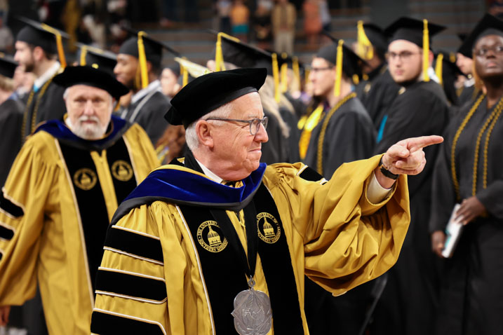 President Paul points to graduates as he makes his way down the aisle. 