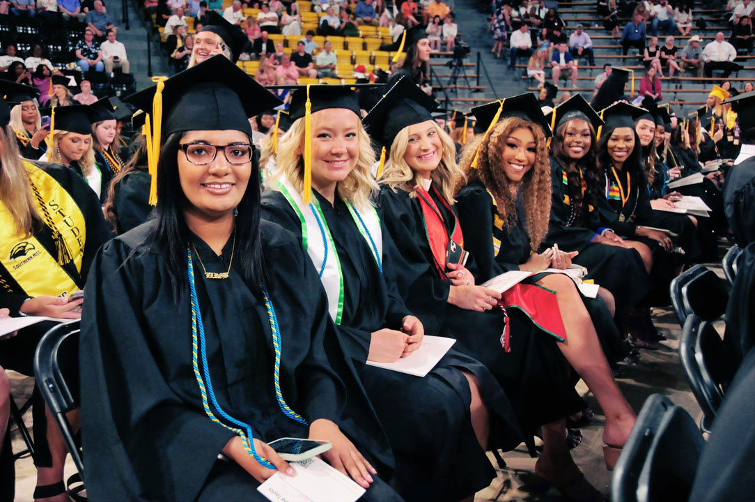 Graduates smile as they await commencement to begin
