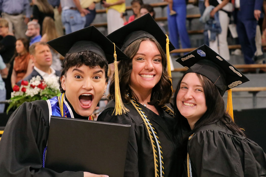 Excited students smile after receiving their diplomas