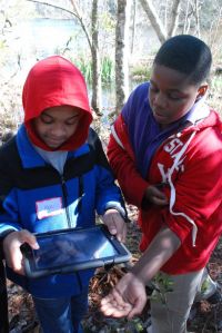Students using iPad on nature hike