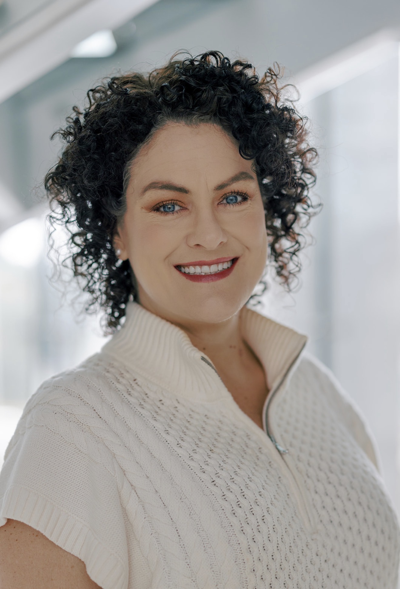 Headshot of Nicole Preiss, curly brunette hair female