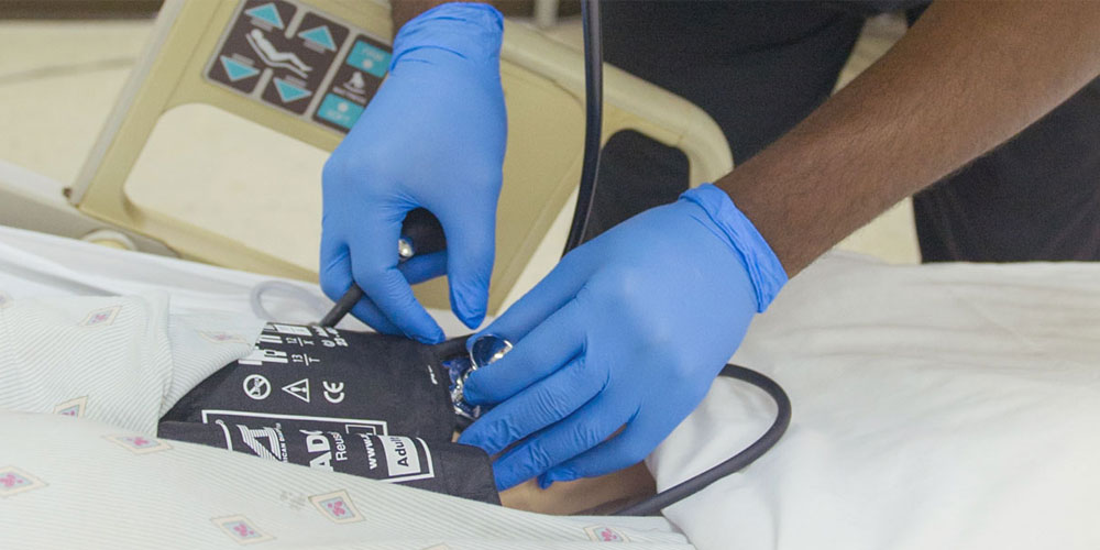 nurse's hands taking blood pressure