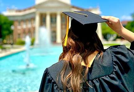 graduate looking at the fountain